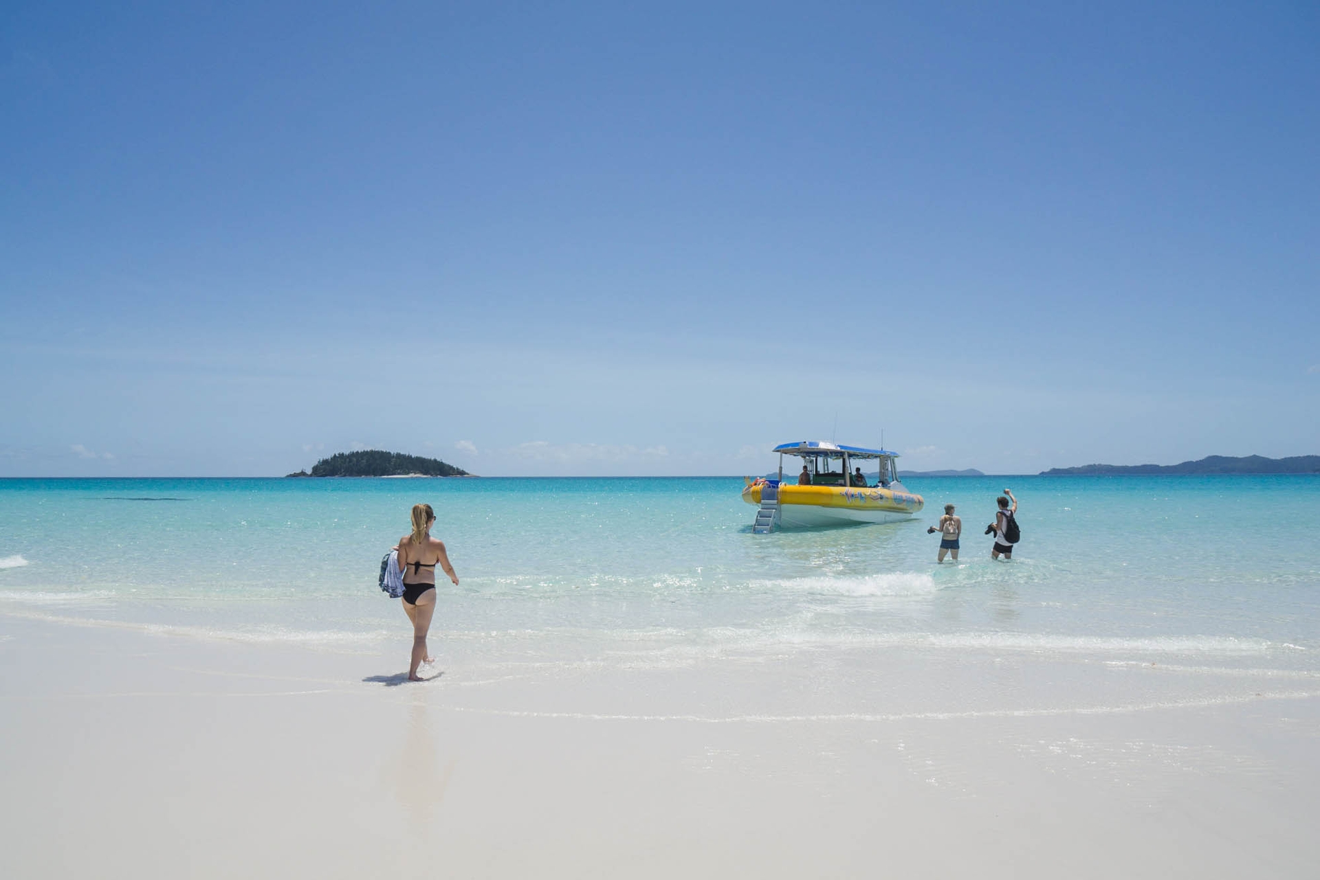 Jami walking on a beach towards our boat in Whitsunday Islands National Park in Queensland, Australia